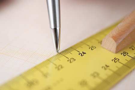 Ballpoint pen drawing line under ruler on graph paper closeup. Construction and architecture conceptの写真素材
