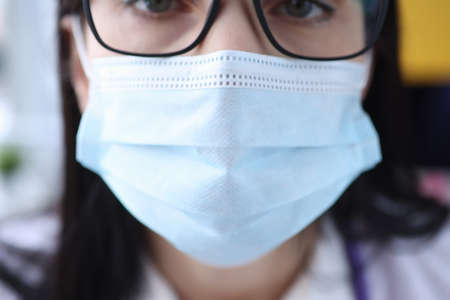 Portrait of woman in protective medical mask and glasses. Mandatory mask mode conceptの写真素材