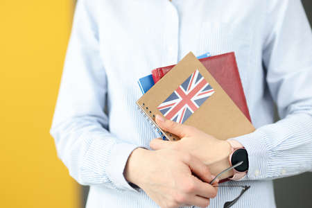 Female silhouette holding diaries with British flag. Self-study foreign languages concept