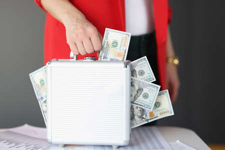 They are holding gray suitcase in which there is lot of money. Fast money online concept