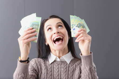 Portrait of joyful woman who holds banknotes in her hands. How to win the lottery concept