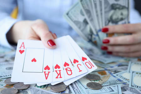Woman holding dollar bills and playing cards in her hands. Gambling conceptの写真素材