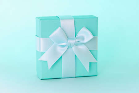Closeup in blue gift box with beautiful ribbon. Designer gift wrapping concept