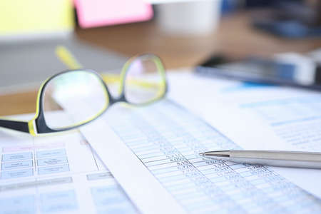 Glasses for vision lying on documents with numbers closeup. Work of an accountant concept
