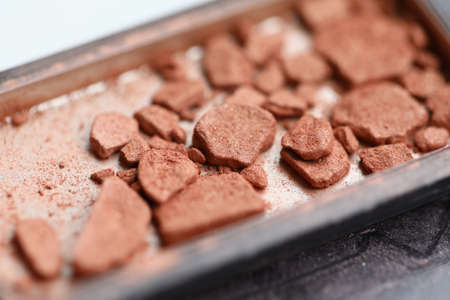 Close-up of construction site waste laying in metal container. Macro shot of used clay materials for renovation. Dry soil texture. Natural small stones. Pieces of garbageの写真素材
