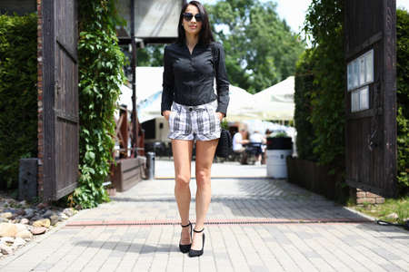 Portrait of businesswoman looking away with gladness and calmness. Smiling businesslady leaving meeting from restaurant. Lady in sunglasses. Beauty and fashion conceptの写真素材
