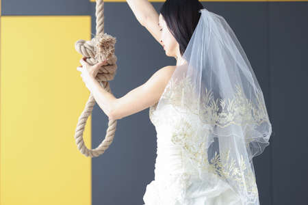 Woman in wedding dress holds her hand on loop for neck