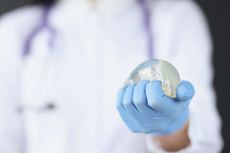 Doctor holds in his hand breast implant for mammary glandsの写真素材