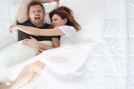 Woman sleeping on man in bed top viewの写真素材