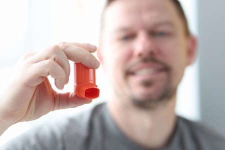 Man holds an inhaler in his hand.の写真素材