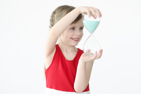 Little girl holding hourglass in her handsの写真素材