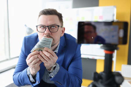 Addicted businessman sniffs smell of money closeupの写真素材