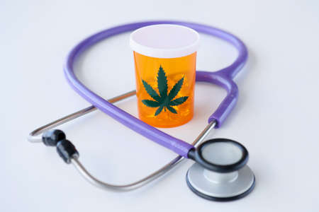 Jar of marijuana pills standing near stethoscope closeupの写真素材
