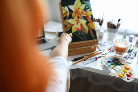 Close-up of talented female creating new picture of flowersの写真素材
