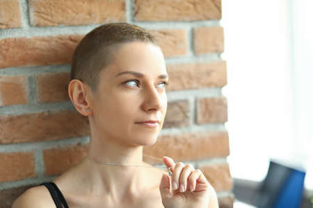 Beautiful pensive woman looking out the windowの写真素材