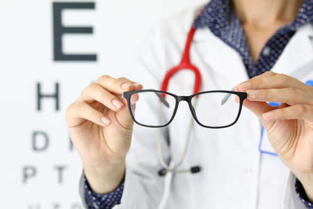 Close-up of person holding black stylish glasses with perfect frame