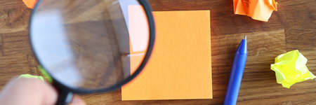 Hand holding magnifying glass over sticker closeupの写真素材