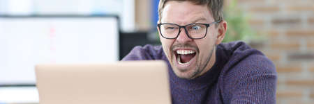 Man with glasses for sight looking into laptopの写真素材