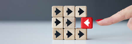 Wooden cubes with black arrows and one red one