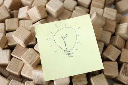 Drawing with light bulb lies on wooden cubesの写真素材