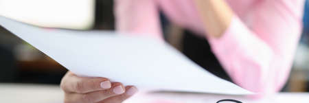 Woman holds documents over work table closeupの写真素材