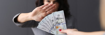 Woman makes negative gesture for money extended to her. Refusal of bribes conceptの写真素材