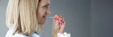 Woman is holding glass with sugar and strawの写真素材