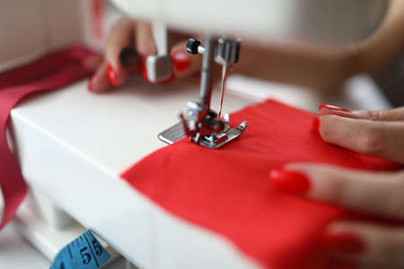 Close-up of dressmaker lady working on sewing machineの写真素材