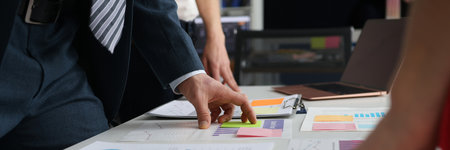 Business people studying charts and documents at table in office