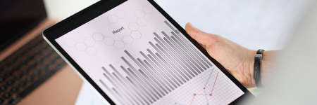 Closeup of tablet with graphs in hands of woman