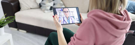 Woman in wheelchair holding tablet with picture closeup