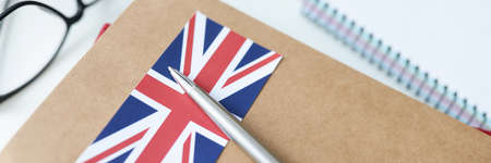 On table is diary with British flag and penの写真素材