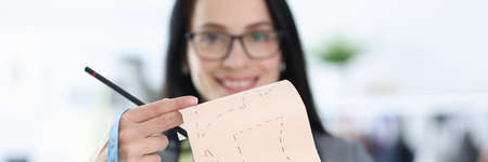 Woman designer is holding mold with sketches of clothesの写真素材