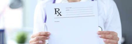 Doctor is holding prescription form for medicinesの写真素材