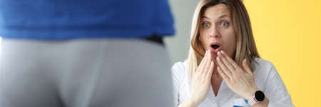 Woman doctor examining patient in shorts and is surprising