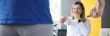 Doctor laughingly looks at male patient with his pants removed