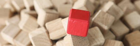 Wooden cubes of beige color in middle there is red cubeの写真素材