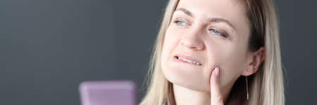 Portrait of pensive woman who holds smartphone in her hands