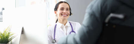 Doctor communicating with disabled patient in wheelchair in office