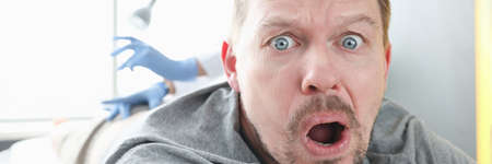 Doctor gives an injection to frightened manの写真素材