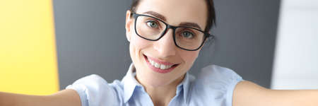 Portrait of young smiling woman taking selfie