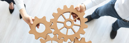 Group of business people stacking wooden gears top viewの写真素材