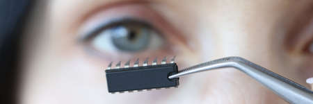 Chip is inserted into womans eye with tweezers closeup