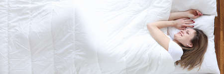 Woman lying in bed and smiling top viewの写真素材