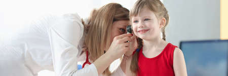 An otorhinolaryngologist examines the ear of little girlの写真素材