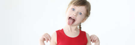 Little girl in red dress showing tongue