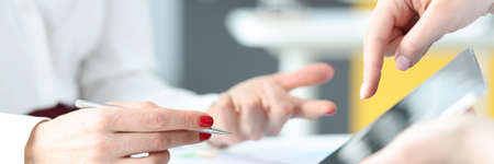Business woman showing information to colleague on digital tablet closeup