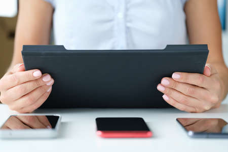 Woman holds tablet on table three smartphones lieの写真素材