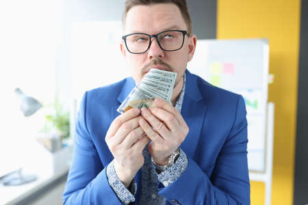 Businessman gets emotionally high from smell of money and earningsの写真素材