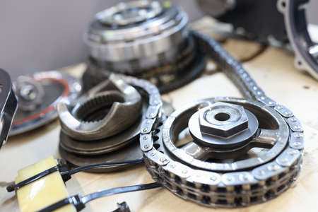 Set of cogwheels connected with steel chain lying at service table